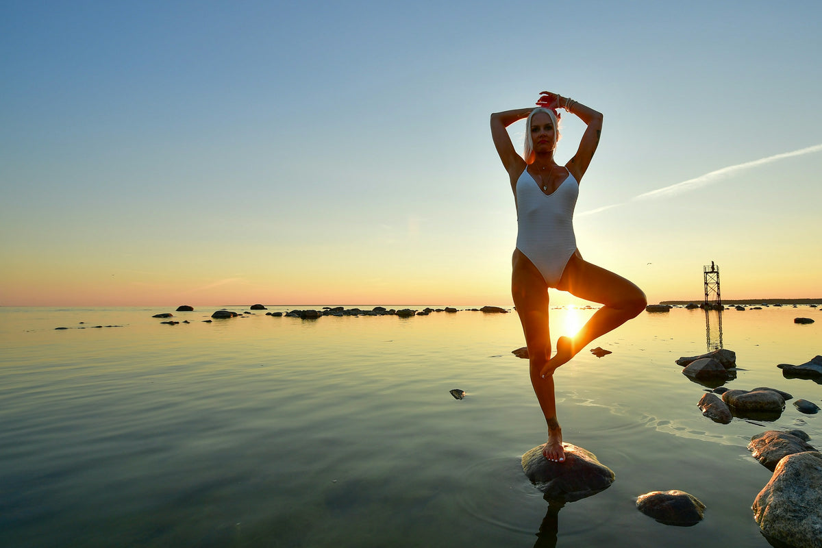 Sunset yoga on the rocks by the water