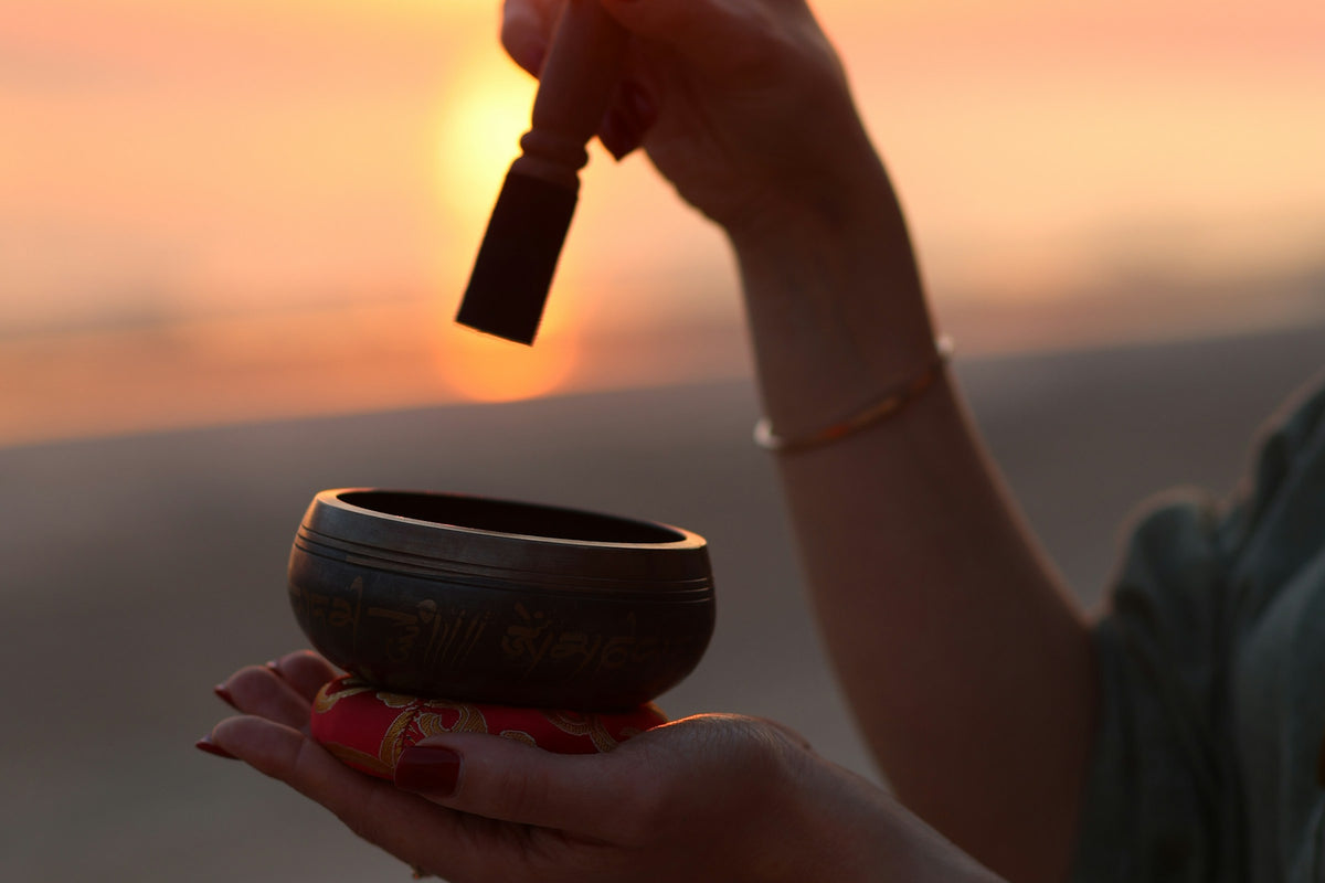 Sound healing with a singing bowl at sunset